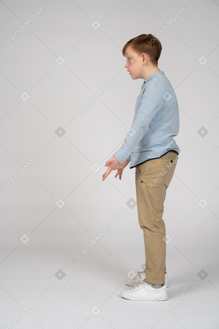 Irritated boy standing with his palms forward