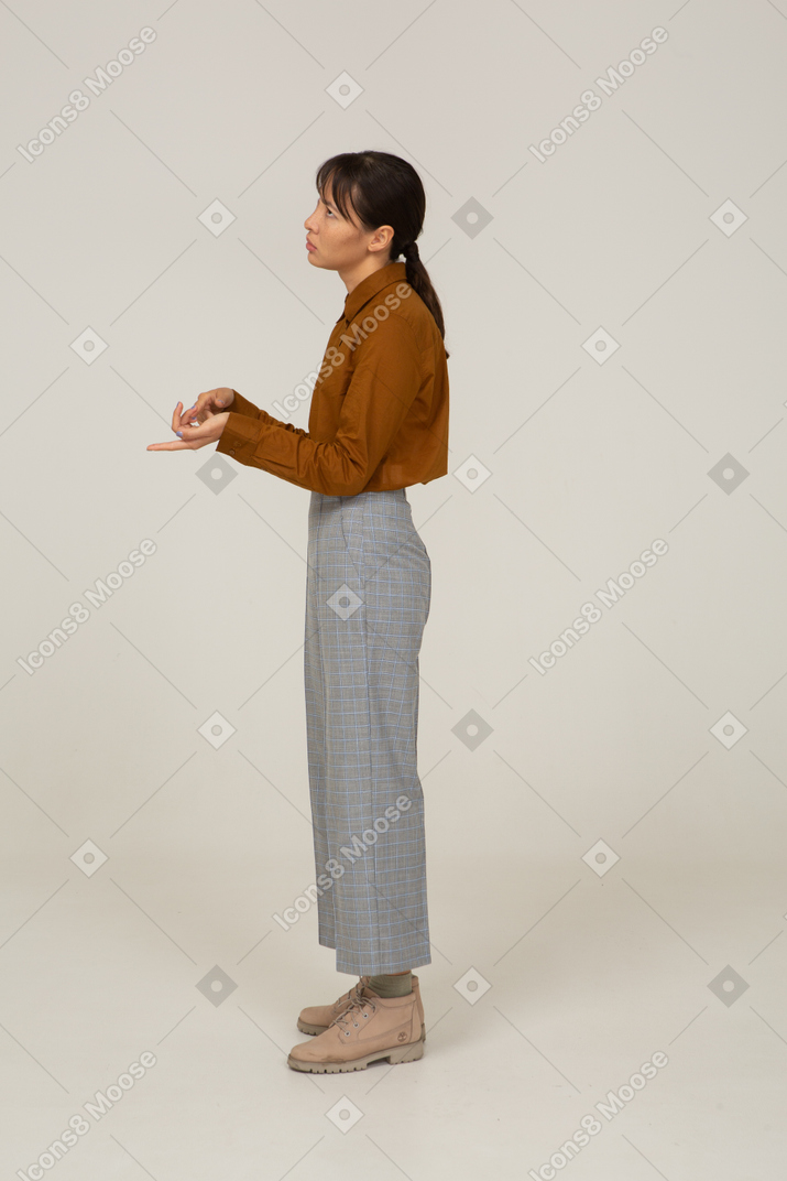 一名身着马裤和衬衫的年轻亚洲女性的侧视图