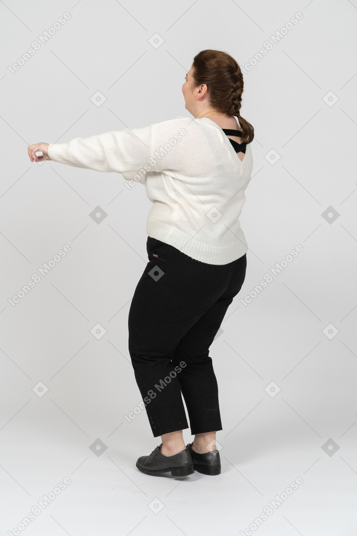 Femme dodue joyeuse dans des vêtements décontractés dansant