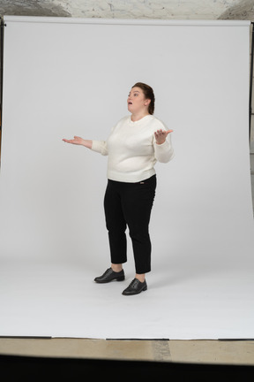 Side view of a plump woman in casual clothes gesturing