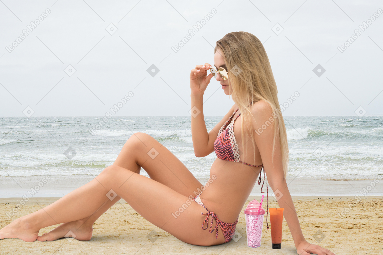 A woman in a bikini sitting on the beach
