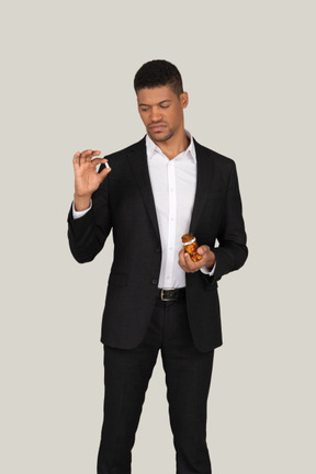 African american man in black suit holding pills