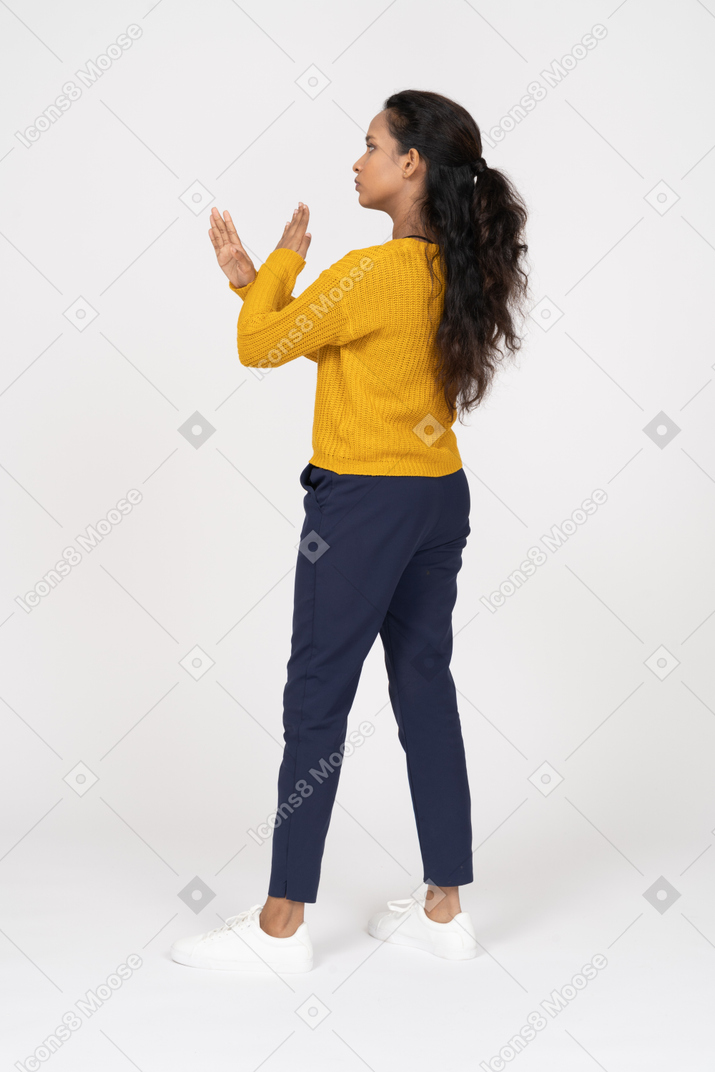 Вид сбоку девушки в повседневной одежде, показывающей жест стоп