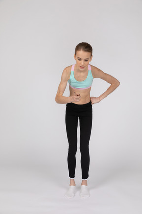 Side view of a teen girl in sportswear raising hand and arguing