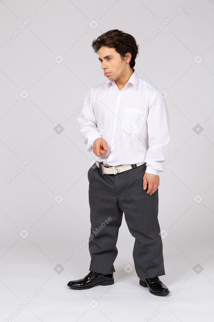 Vista frontal de um homem em trajes formais olhando de lado e apontando algo