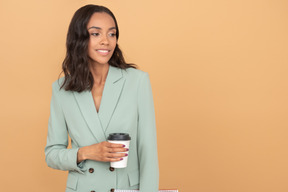 Элегантная молодая деловая женщина держит чашку кофе
