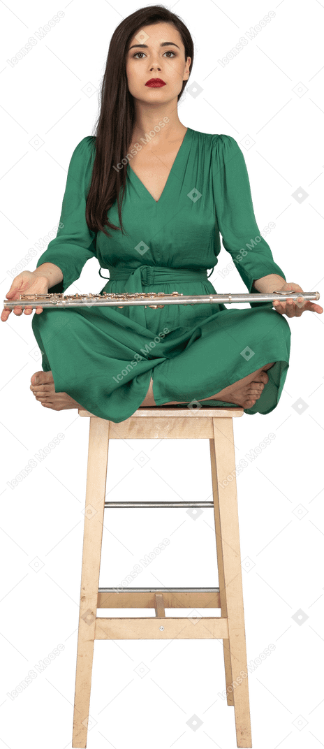 木製の椅子に座ってクラリネットを膝に抱えた若い女性の全身像