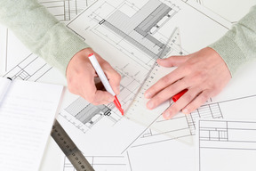 Male hands drawing architect blueprint