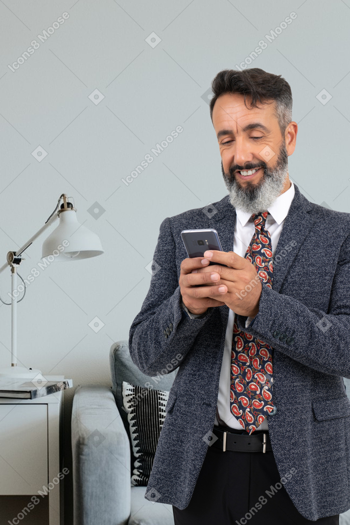 A man in a suit is looking at his cell phone