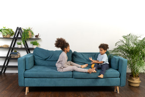 Good looking boy and girl play on the sofa