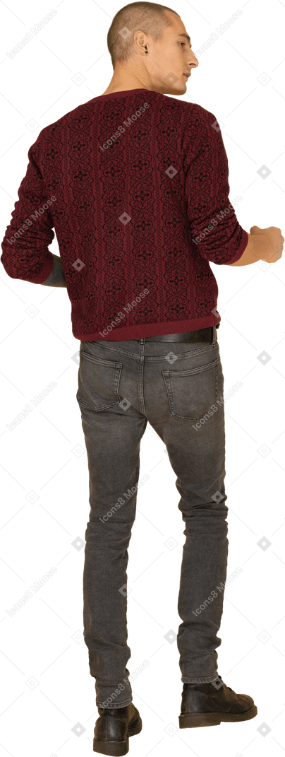 赤いプルオーバーで身振りで示す若い好奇心旺盛な男の背面図