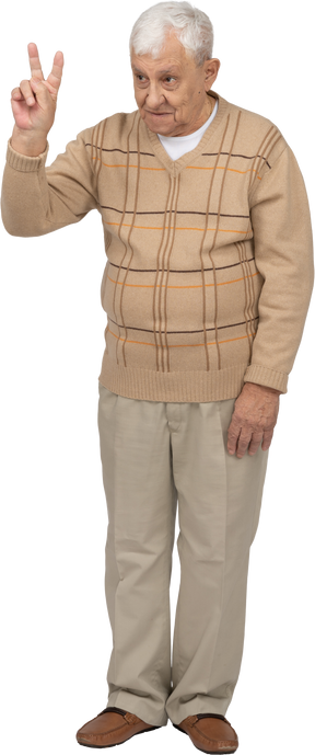 一位穿着休闲服的老人的正面图显示 v 标志