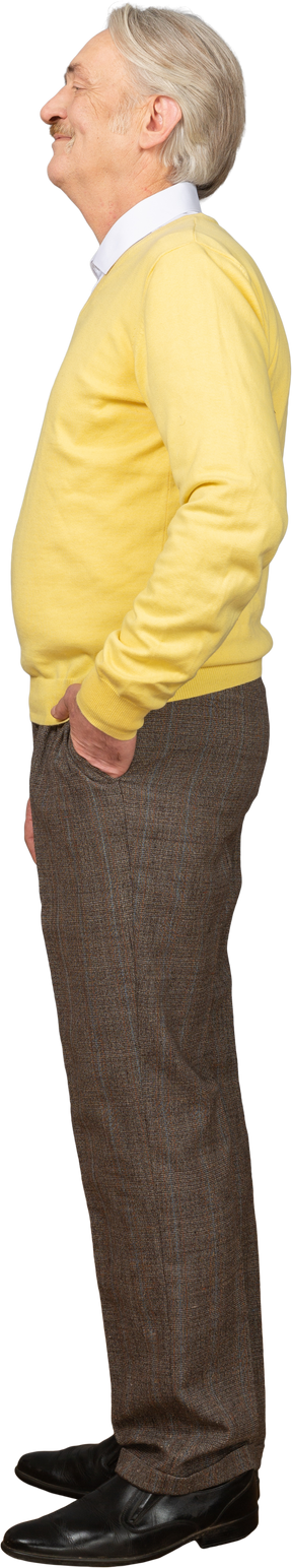 Vista lateral de un anciano complacido vistiendo jersey amarillo y poniendo la mano en el bolsillo