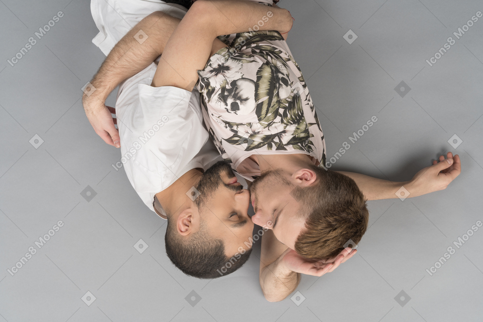 Flat lay of two young caucasian men lying on the floor hugging each other