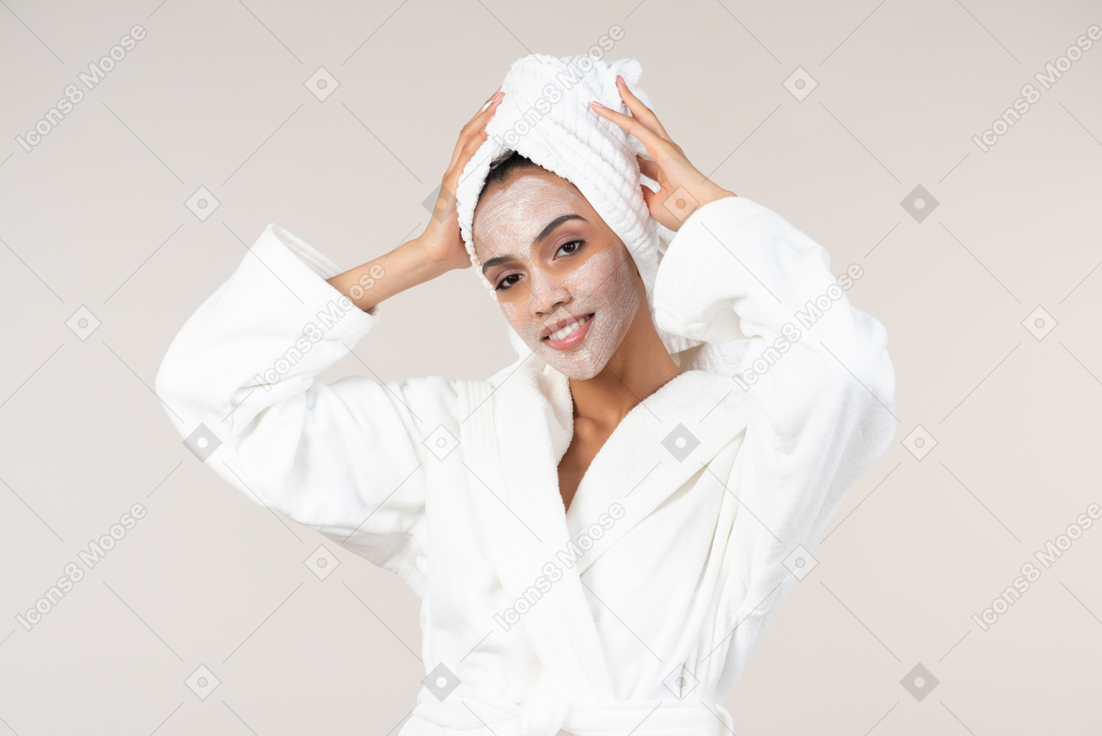 彼女の肌ケアルーチンを楽しんでいる白いバスローブとヘッドタオルで黒人女性