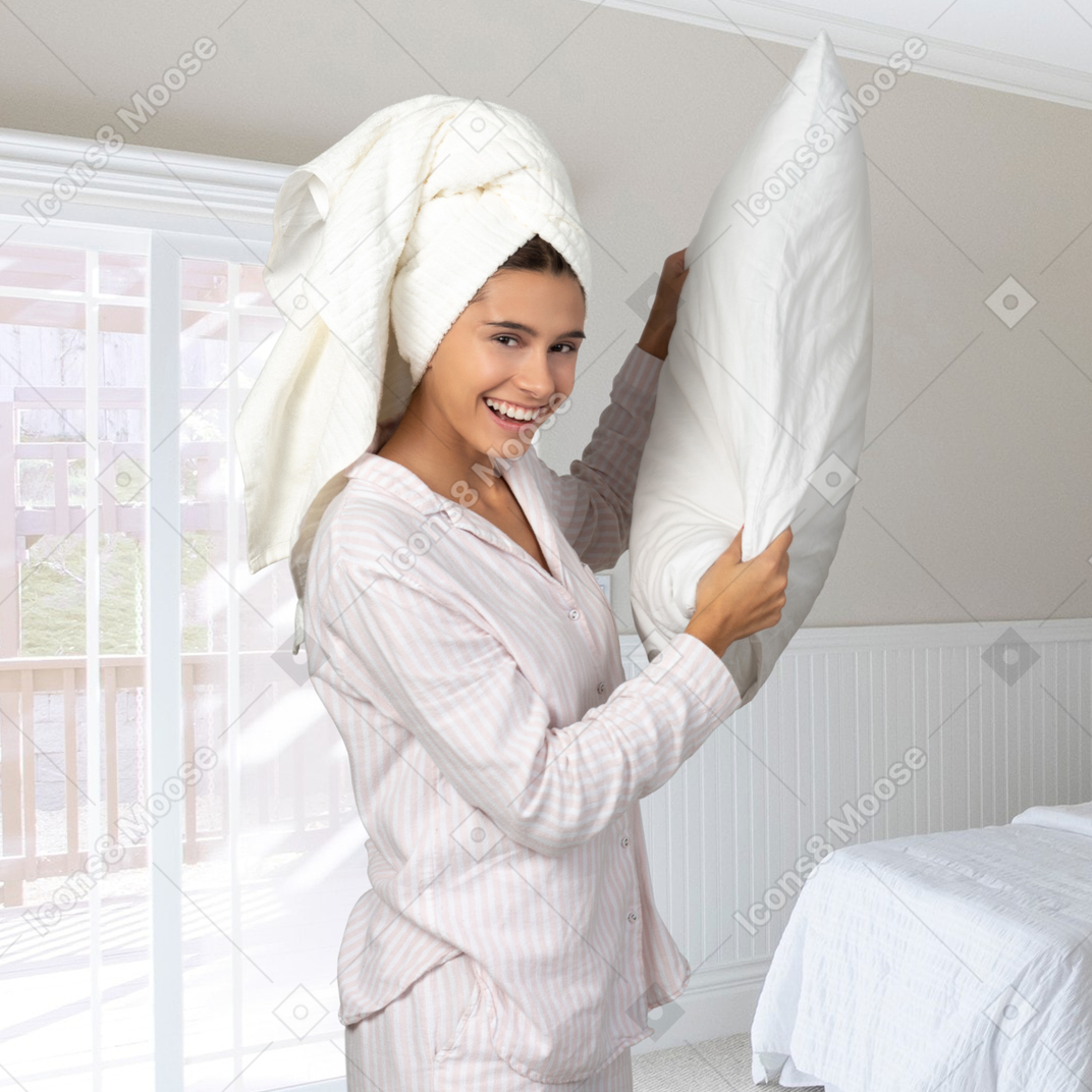 A woman holding a pillow in a bedroom