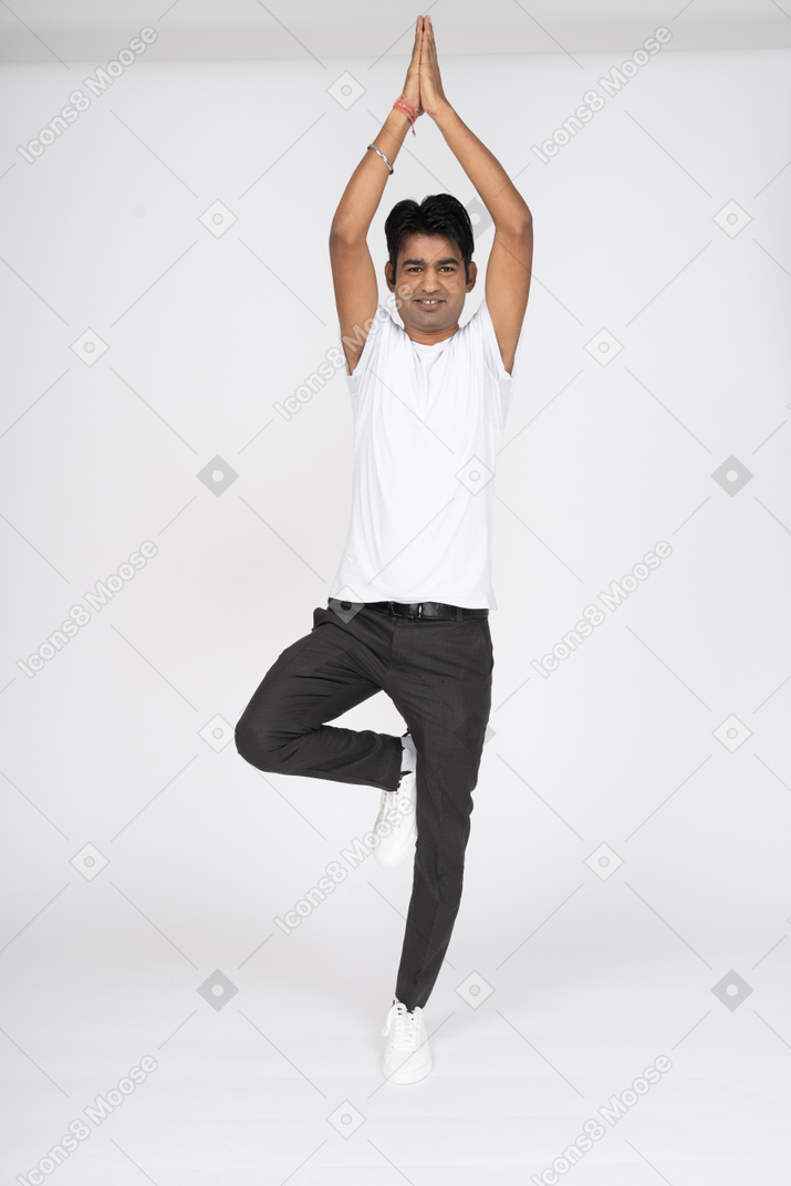 Hombre en camiseta blanca haciendo yoga