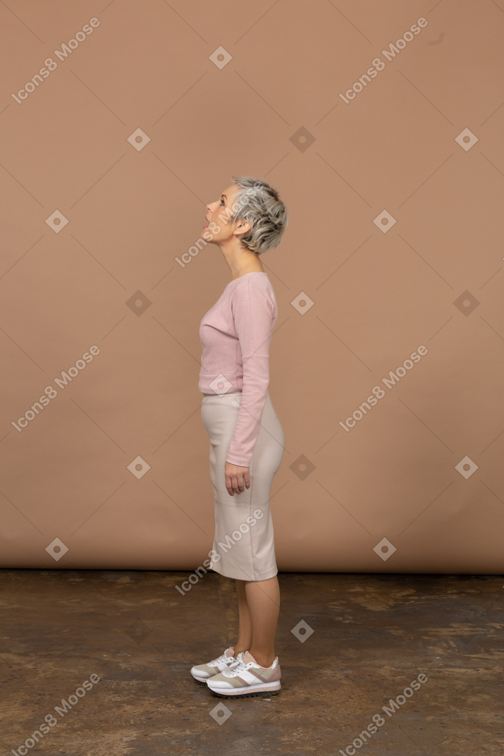 Vista laterale di una donna in abiti casual in piedi con la bocca aperta