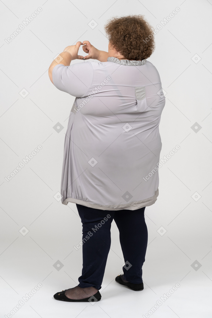 Rear view of a woman showing love sign