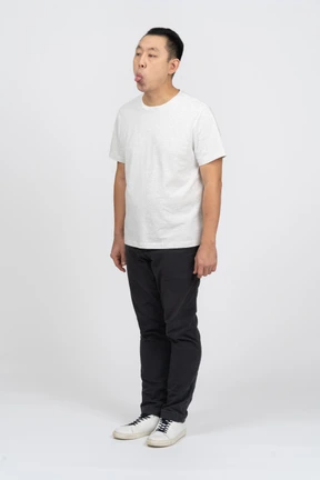 Three-quarter view of a man in casual clothes showing tongue