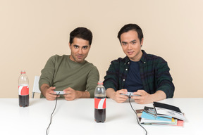 Interracial friends sitting at the table and playing video game