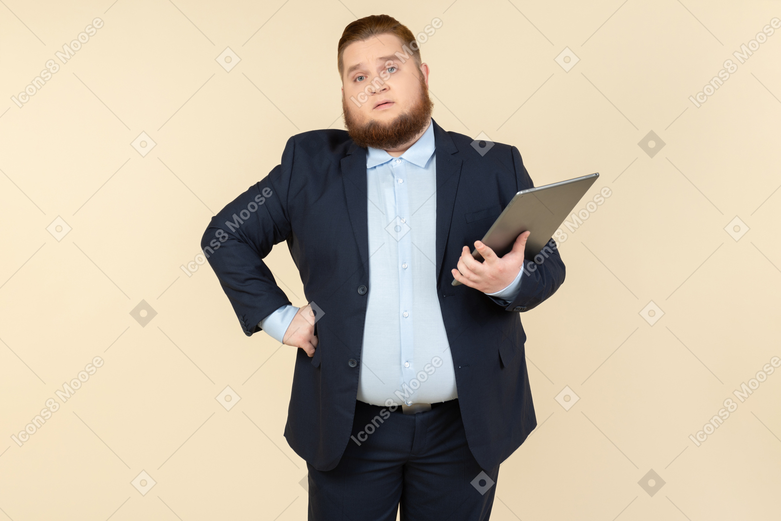 Serious looking young overweight office worker holding digital tablet