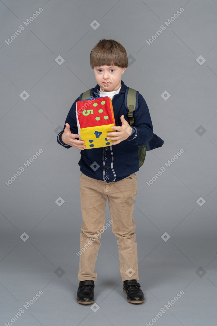 Portrait of a schoolboy holding plush dice