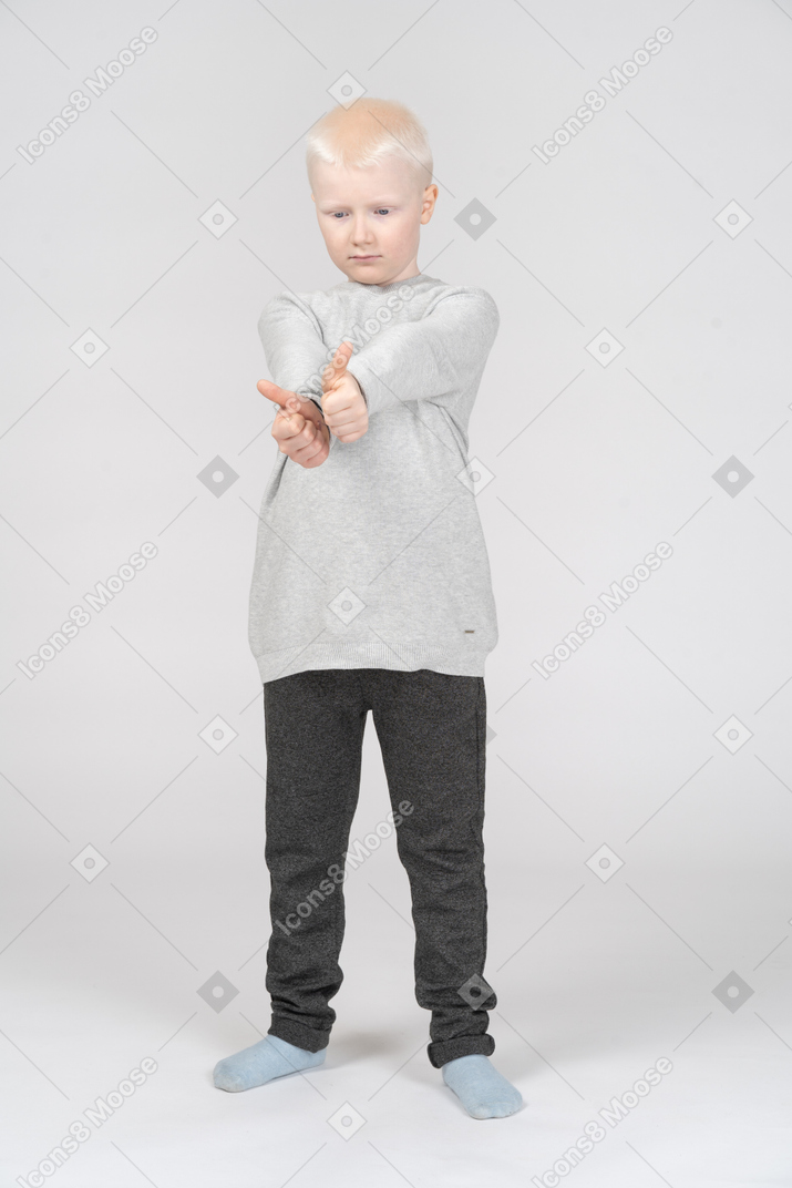 Маленький мальчик показывает два больших пальца вверх