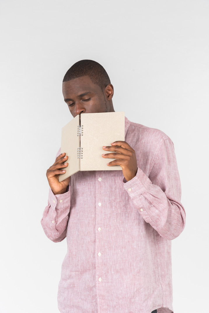 Good looking young man holding a notebook