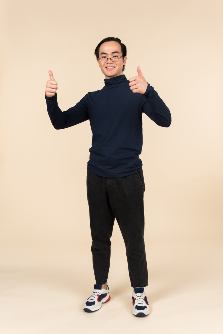 Young asian man showing thumbs up