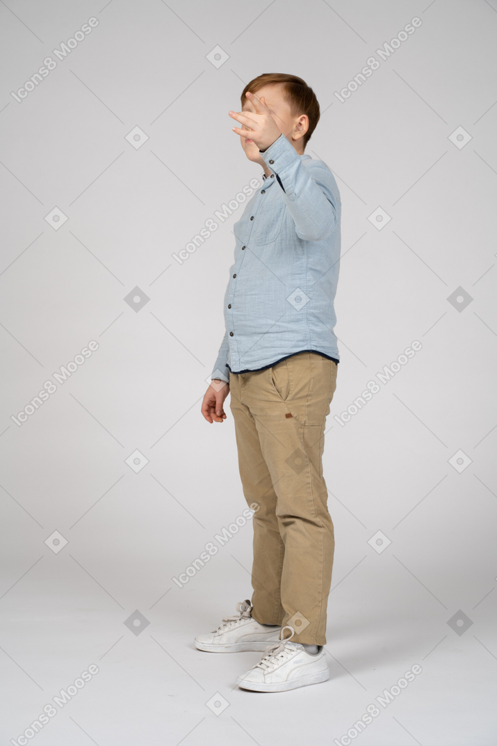 Boy in shirt and pants pointing at something