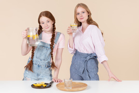 Two young girls holding lemon water