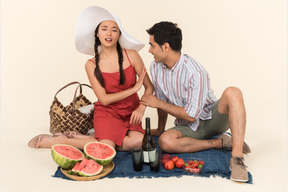 Young interracial couple having picnic and young woman seems like doesn't like something