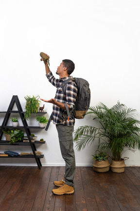 Side view of a backpacker holding up an empty flask