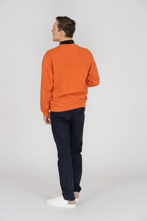 Young man in orange sweatshirt standing