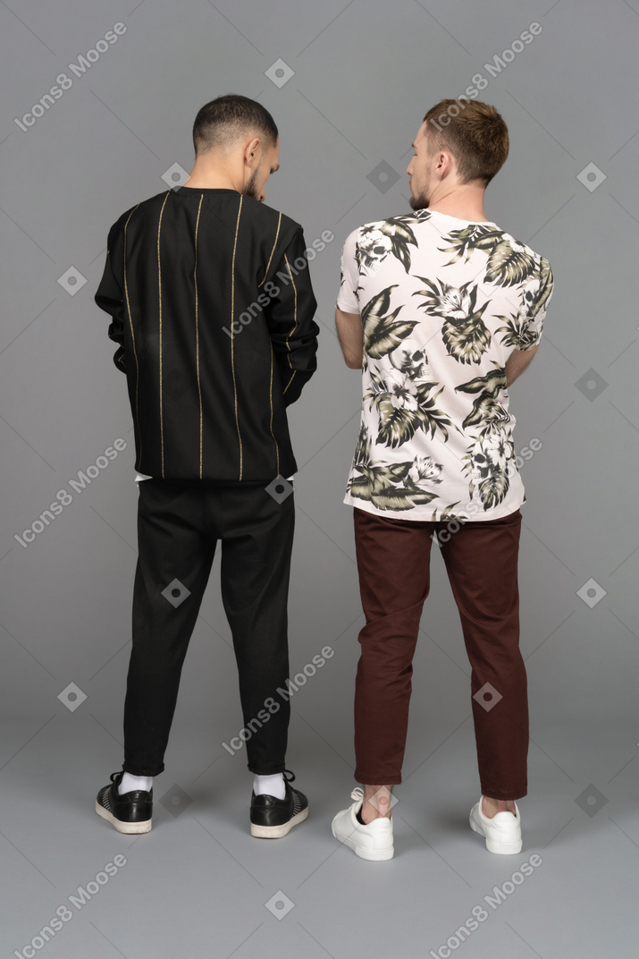 お互いを見ている2人の若い男性の背面図