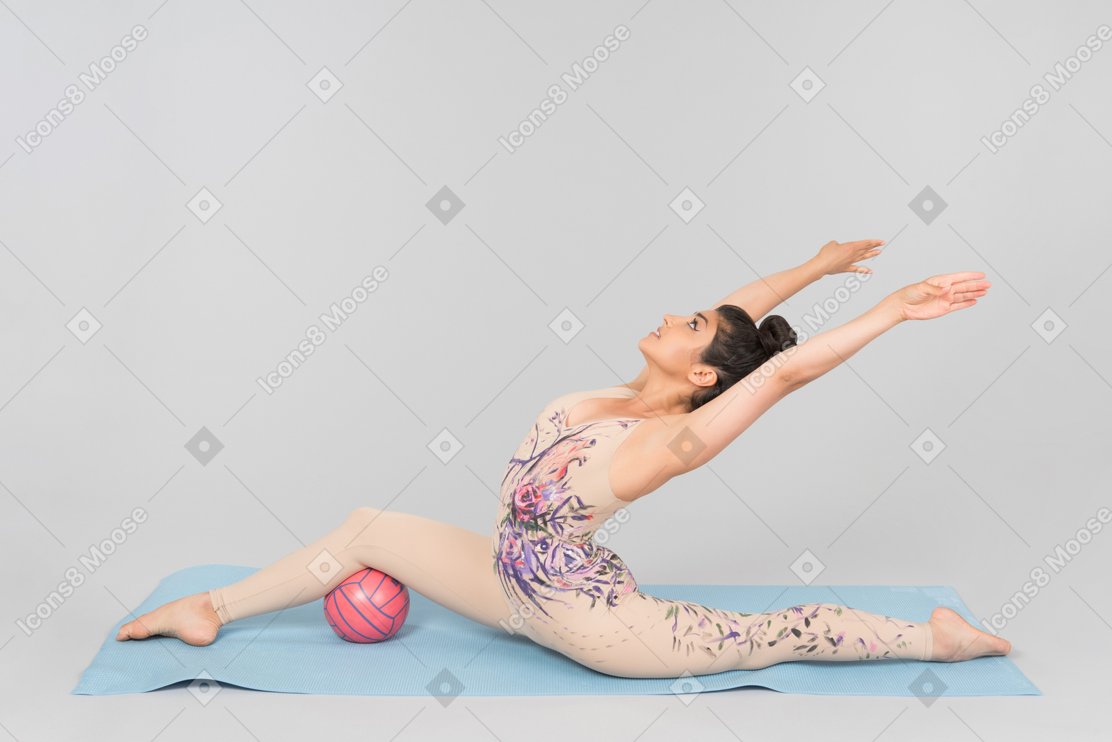 Young indian gymnast sitting on yoga mat and stretching body