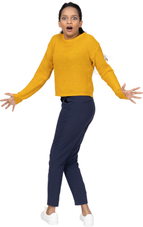Emotional girl in casual clothes standing with outstretched arms and looking at camera