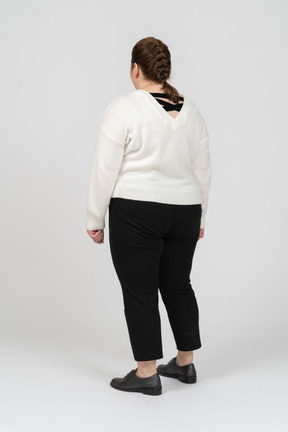 Плюс размер женщина в белом свитере стоя