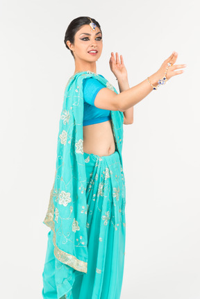 Jeune femme indienne en sari bleu debout en position de danse