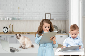 A little girl and a little boy are looking at something on a tablet