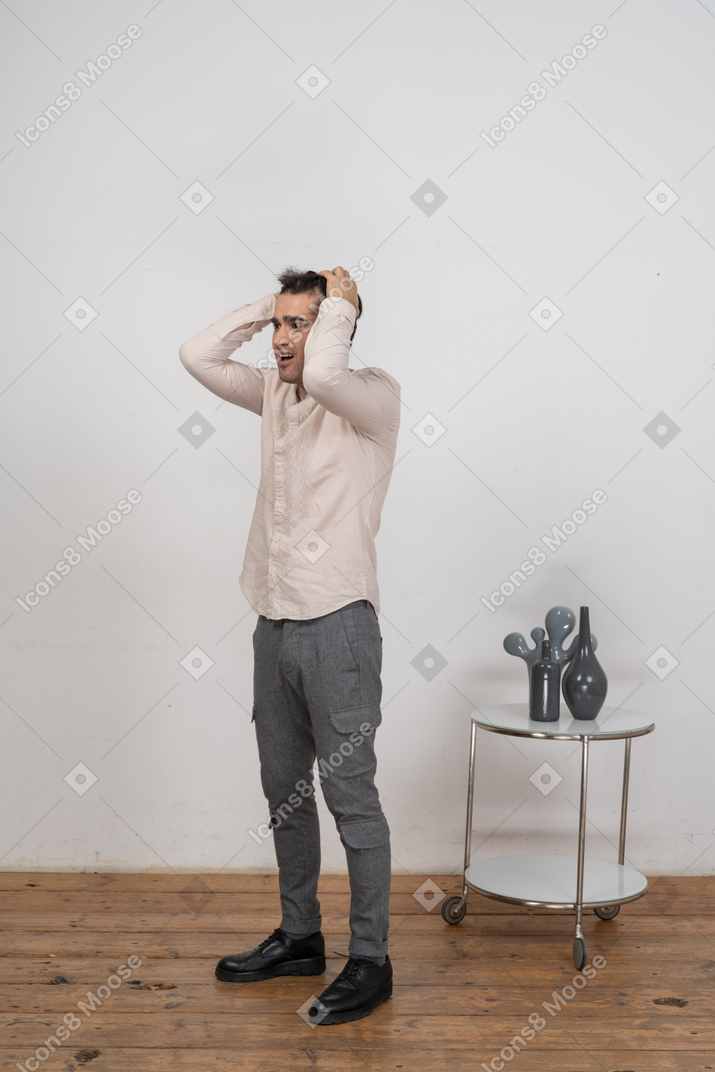 Man in shirt standing with hands behind head