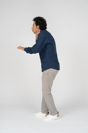 Side view of a man in casual clothes chocking himself