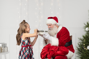 Bambina che apre il suo regalo da babbo natale