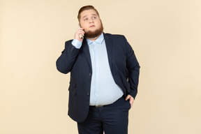 Serious looking young overweight office worker talking on the phone