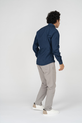Rear view of a man in casual clothes looking at something