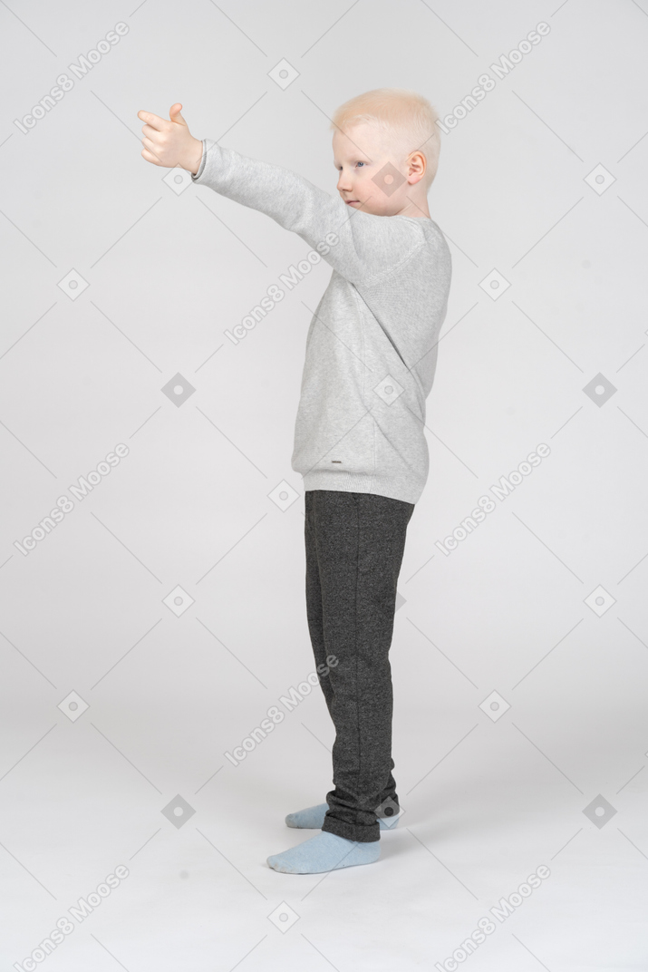 Menino em roupas casuais, levantando a mão