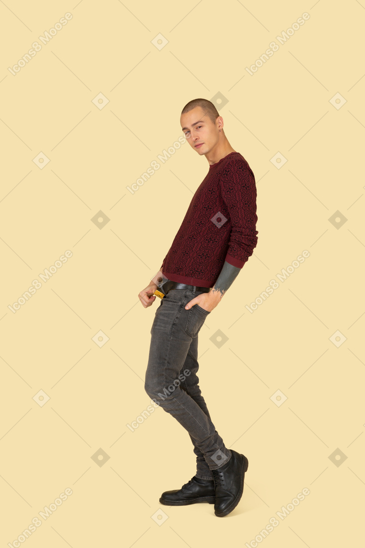 Vista laterale di un giovane uomo in pullover rosso toccando la cintura