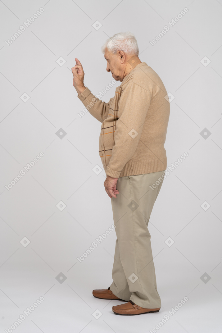 Vista lateral de un anciano con ropa informal que muestra un gesto correcto