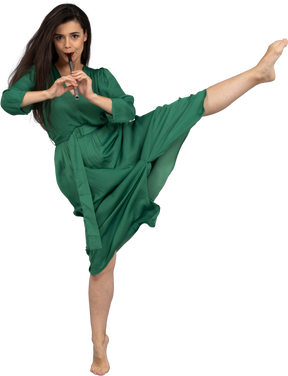 一位年轻的女士，穿着绿色的长笛，跳舞的前视图